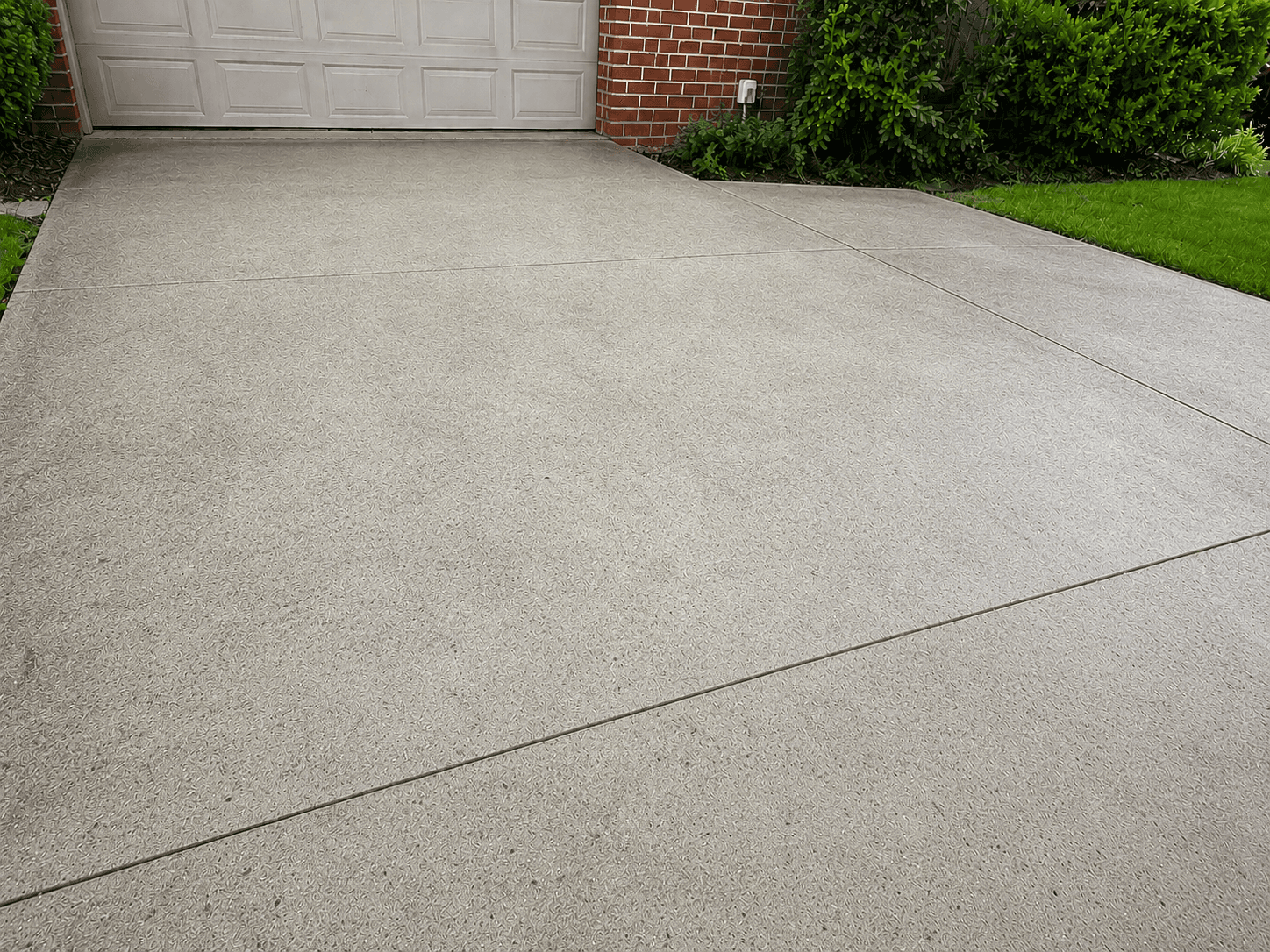 Concrete driveway after pressure washing — surface cleared and rinsed
